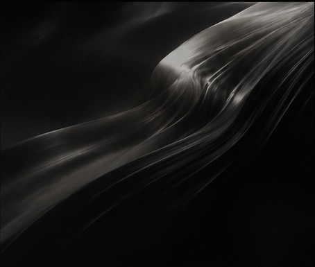 Abstract flowing metallic form in a dark cinematic frame